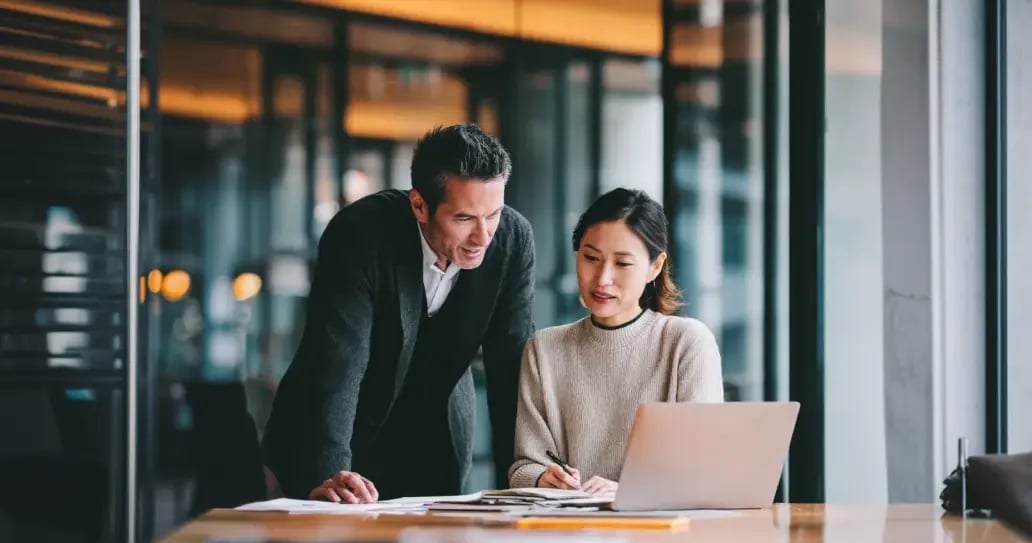Two professionals reviewing a document with charts during an office consultation