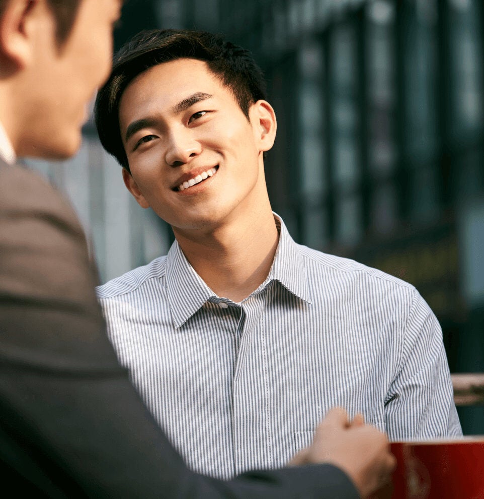Asian businessman smiling at colleague 