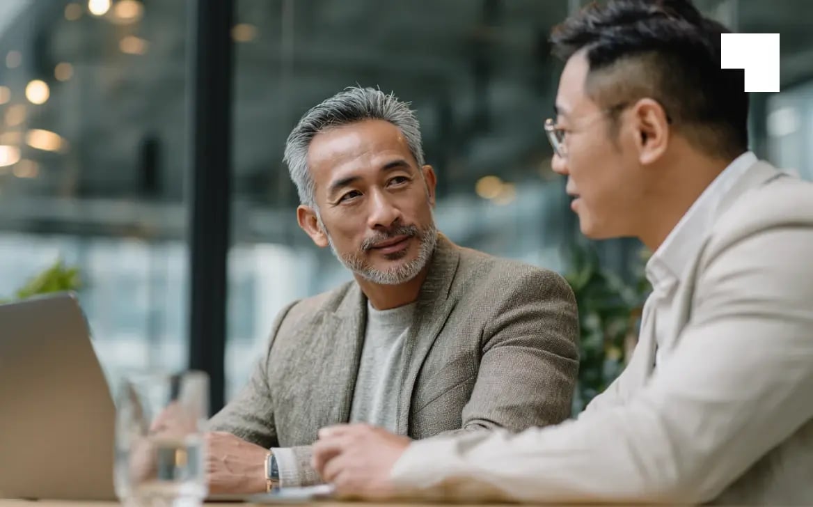 Two business professionals discussing compliance strategy in modern office setting