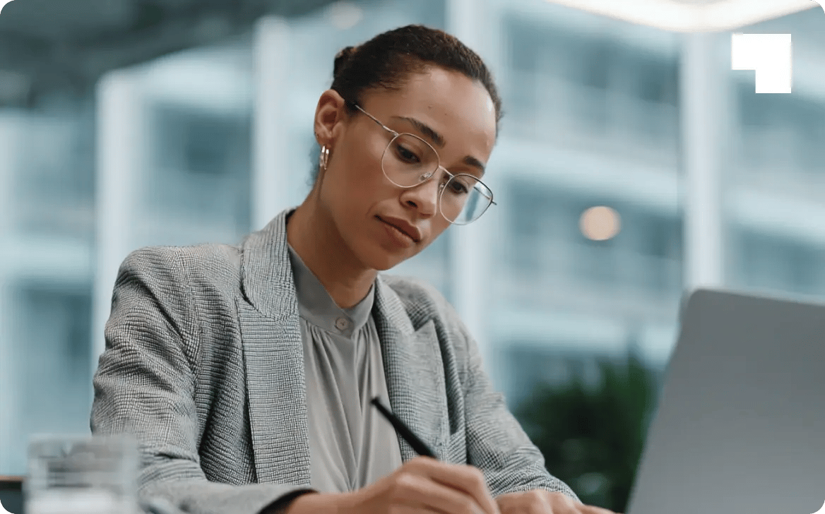 Professional woman in business attire reviewing legal entity identifier documentation at modern office desk