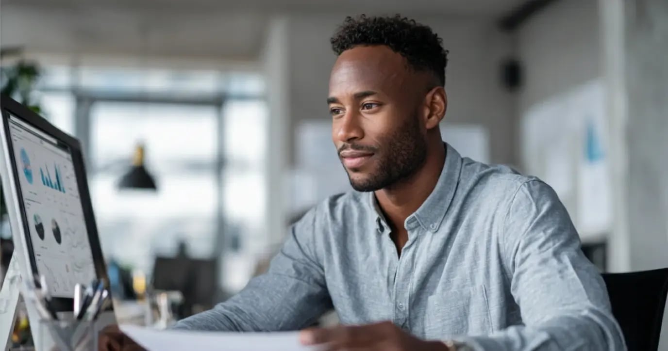 Professional businessman analyzing financial data and charts on computer screen in modern office