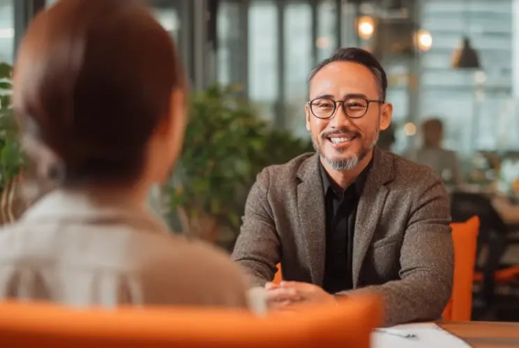 Professional businessman with glasses smiling during business meeting in modern office