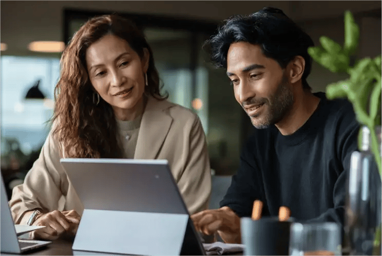 Two professionals collaborating on tablet reviewing fund services and investment solutions in modern office