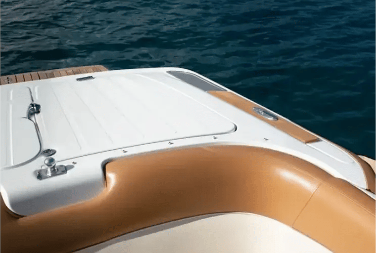 Luxury yacht bow with tan leather seating and white deck on calm blue water