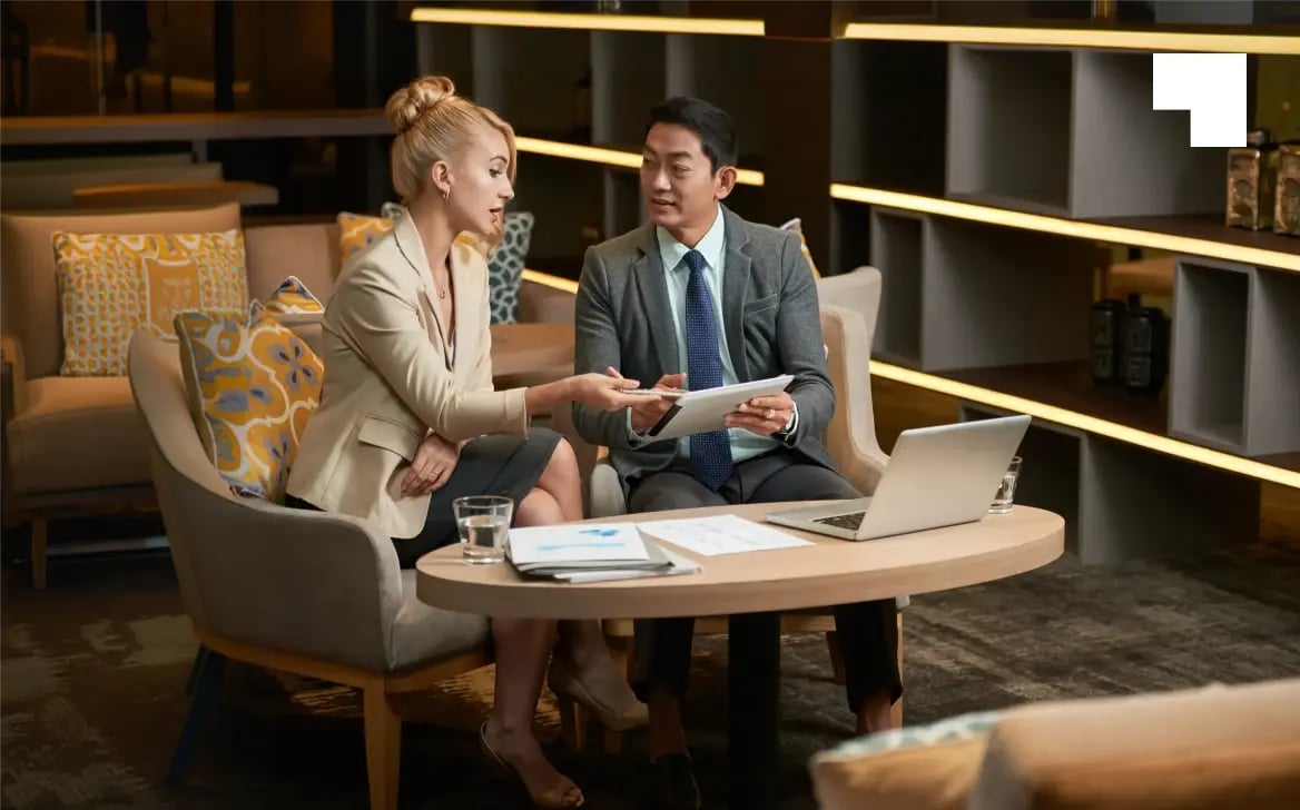 Two business professionals reviewing trust documents in modern office setting during wealth planning consultation