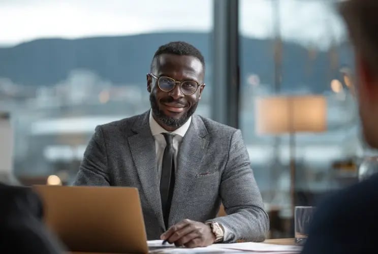 Professional advisor in suit meeting with client in modern office to discuss wealth planning and trust services