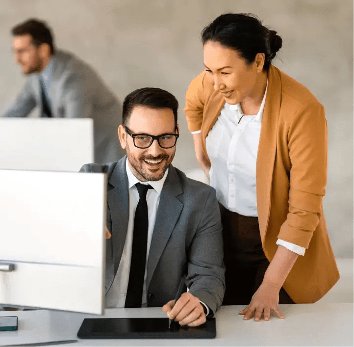 Businesswoman and businessman reviewing desktop