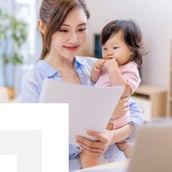 mother working while holding her baby
