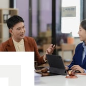 Two colleagues discussing work at a table