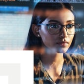 woman wearing glasses stares at a computer