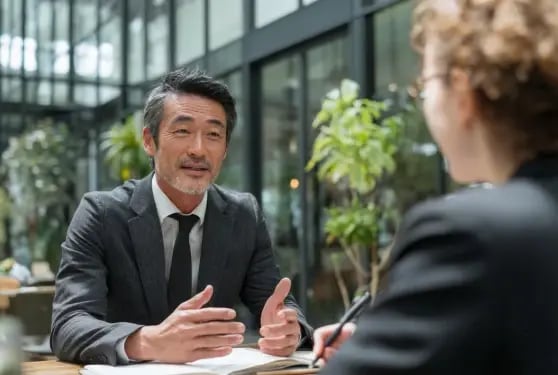 asian_businessman_in_suit_consulting_with_corporate_client_in_modern_office_setting