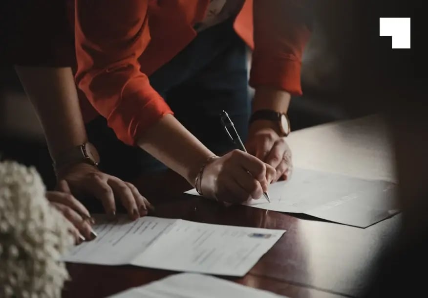 Business professionals signing registered agent service documents at office desk