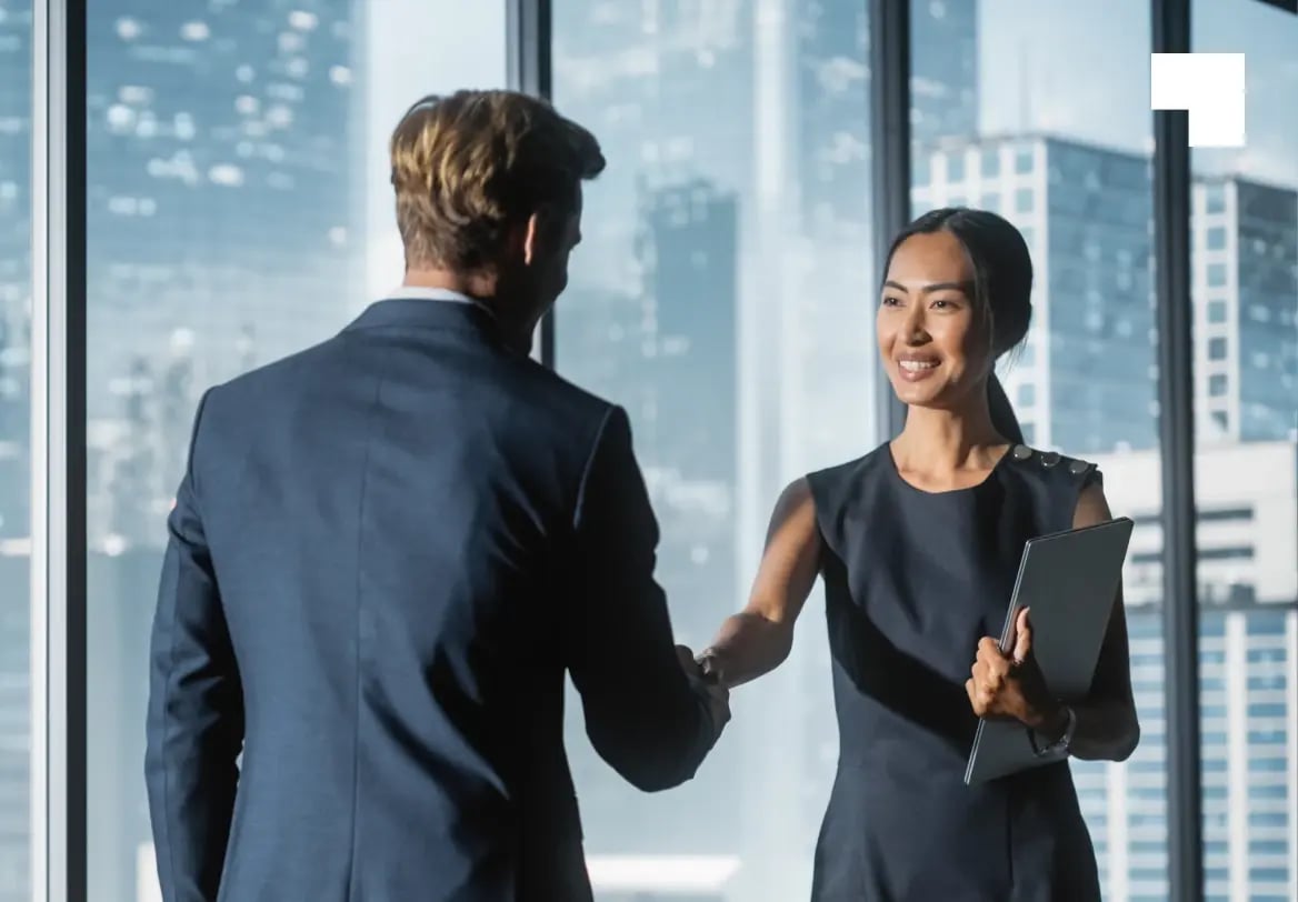 Business professionals shaking hands in modern office discussing global workforce management solutions