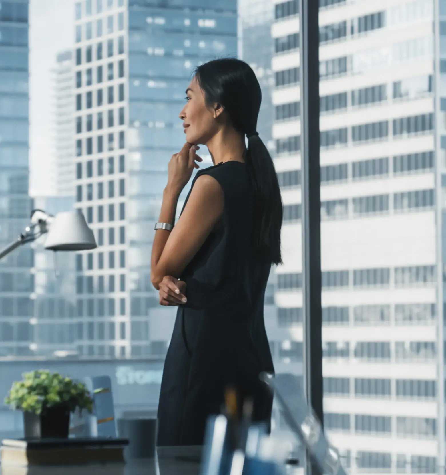 Professional businesswoman in modern office overlooking city skyline, representing global workforce management solutions