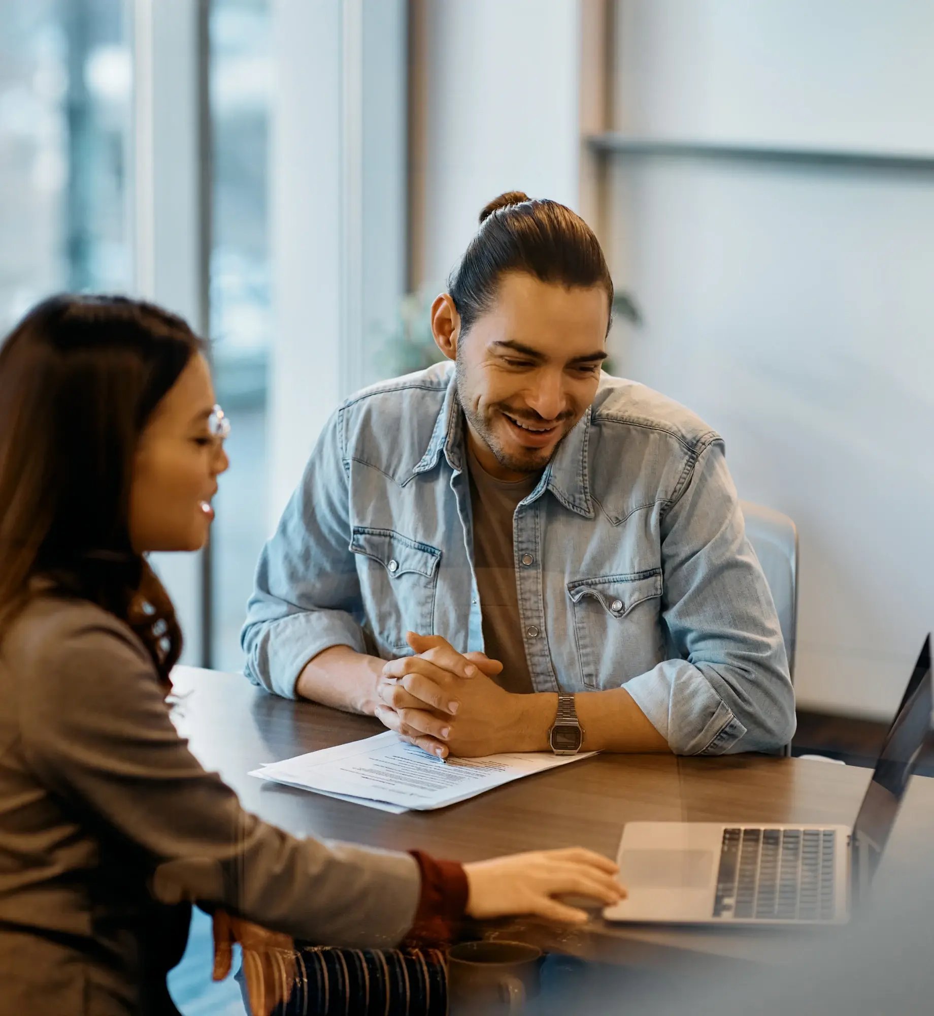 business_professional_reviewing_payroll_outsourcing_contract_with_hr_consultant_at_modern_office_desk