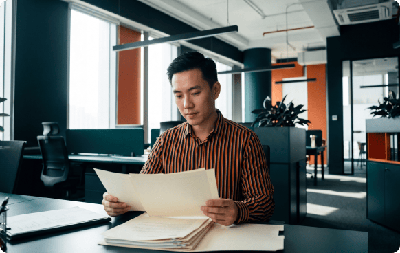 An asian men reviewing document on his desk